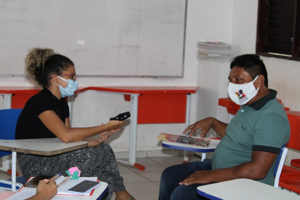 A estudante entrevistando o líder quilombola da comunidade de Pedreiras, município de Santa Rita.